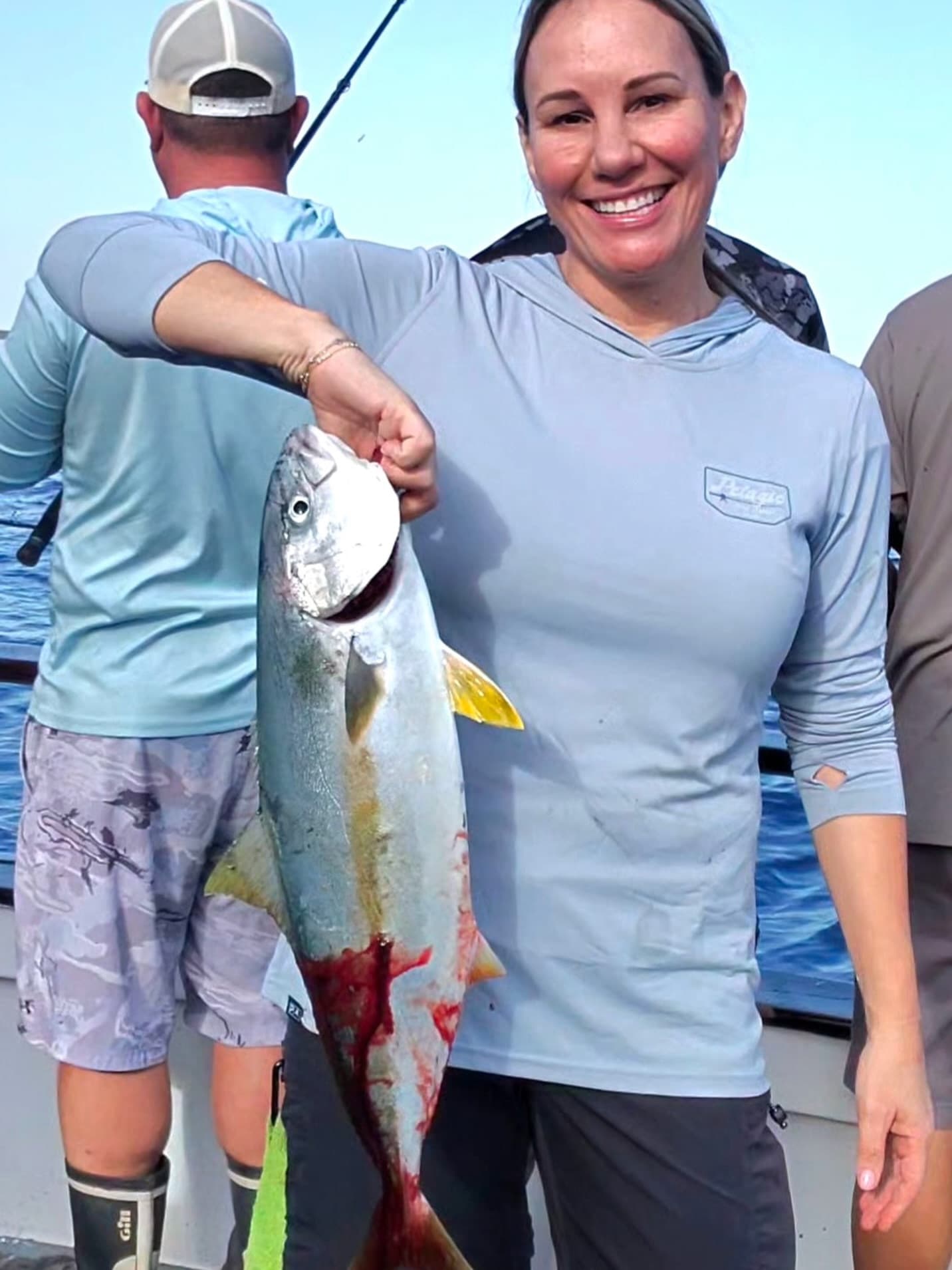 Angler shows off a bled yellowtail on deck