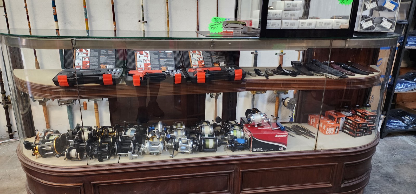 Counter showcase of reels, tackle boxes, and terminal gear