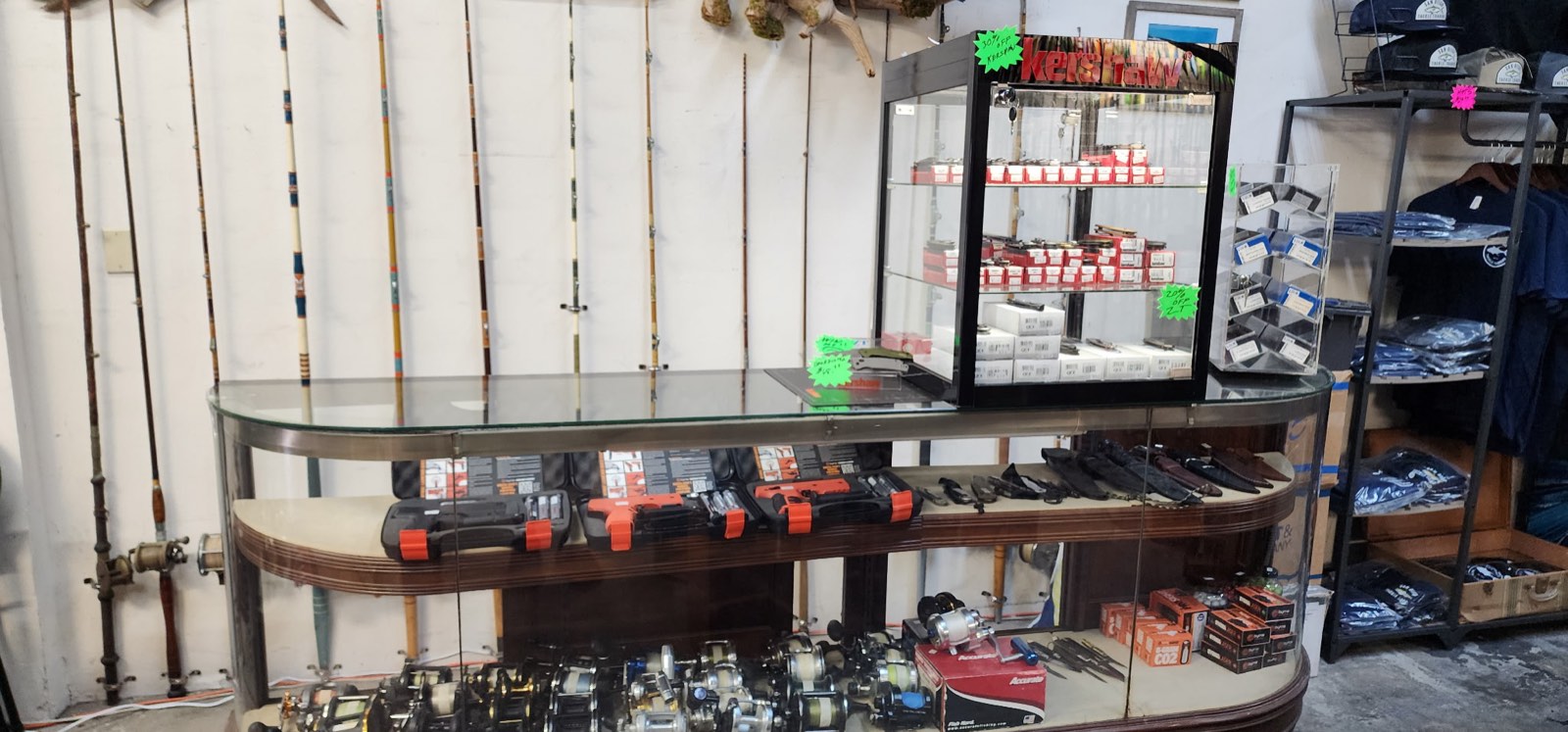 Main showcase with trays of reels, rods racked on the wall behind