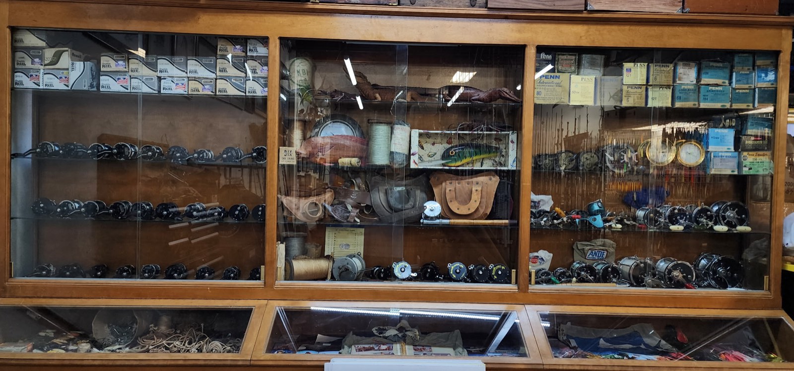 Wall showcase of vintage tackle — early reels, lures, and memorabilia